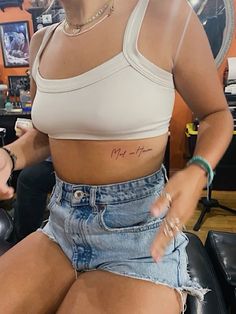 a woman sitting on top of a chair with her hand in her pocket and writing on her stomach