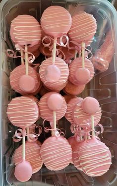 pink cake pops are arranged in a plastic container