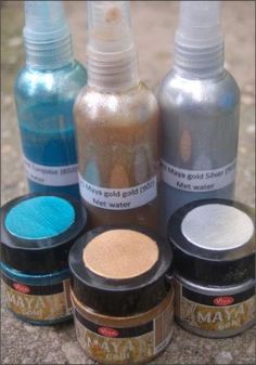 several different types of paint sitting on top of a stone floor next to each other