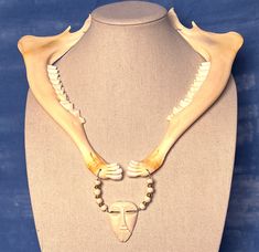 a mannequin's torso with bones and beads on it