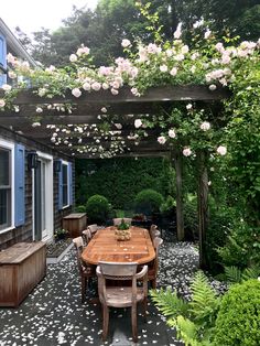 an outdoor dining area with wooden table and chairs