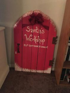 a red door with writing on it that says santa's workshop elf entertainment only