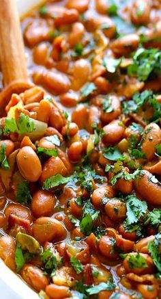 a white bowl filled with beans and cilantro