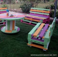 an outdoor table and benches made out of pallet wood, painted in different colors