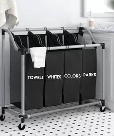 three black laundry baskets sitting on top of a metal rack