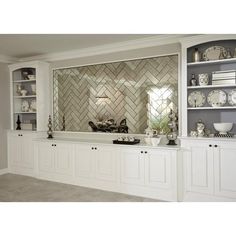 a kitchen with white cabinets and glass tile backsplash in the back wall area