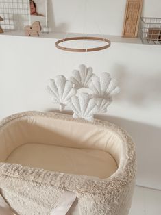 Seashell mobile Our best-selling boucle mobile just got an upgrade, meet our new nursery decoration, the seashell mobile. This is top-tier craftsmanship, with each mobile lovingly and delicately handmade in Yorkshire. Perfect for a neutral space, this decorative nursery accessory is made from luxury, textured micro boucle fabric in ecru. Watch as the shells dance away above your little one's head as they fall asleep. Complete the set with our seashell cushion and boucle moon cushion. Material: 100% polyester micro boucle / cotton string / Hoop: 100% FSC sustainable beech wood Stuffing: Super carded hollow fibre polyester / Safety: CE & BS5852 Measurements: Shell approx. 13cm x 13cm  Wood hoop: 20cm (lowest hanging mobile piece falls about 27cm from hoop) Please note:  There is a loop at th Surfer Nursery, Seashell Mobile, Ocean Nursery Decor, Wooden Cribs, Neutral Nursery Decor, Shell Mobile, Mermaid Nursery, Ocean Nursery, Nursery Decor Neutral