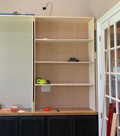 an empty room with shelves and tools on the floor