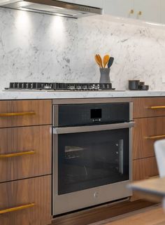 a kitchen with marble counter tops and wooden cabinets