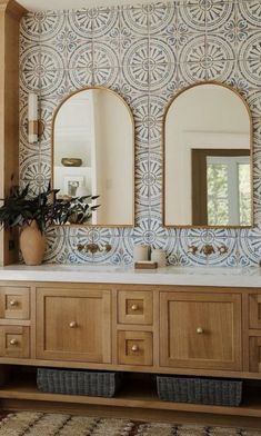 a bathroom vanity with two mirrors above it