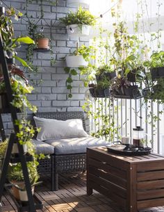 some plants are growing on the side of a brick wall in an apartment balcony area