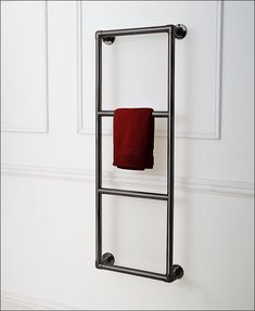 a towel rack with two red towels hanging on it's sides, in front of a white wall