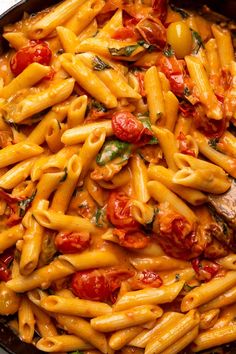 a skillet filled with pasta and tomatoes