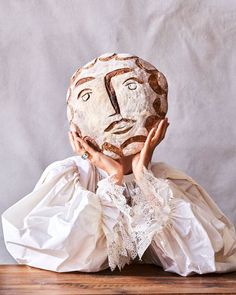 a person with a paper mache covering their face