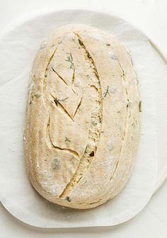 a loaf of bread sitting on top of a white paper towel next to a knife and fork