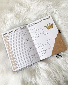 a planner with a crown on it sitting on top of a white fur covered floor