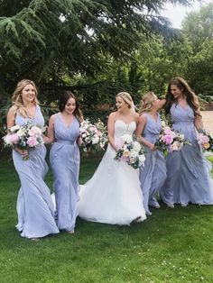 a group of women standing next to each other on top of a lush green field