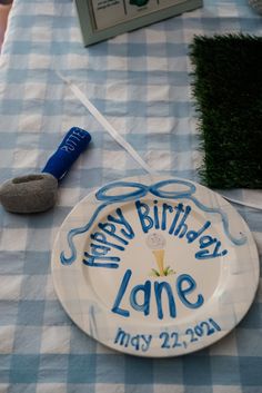 a blue and white table cloth with a happy birthday plate on it