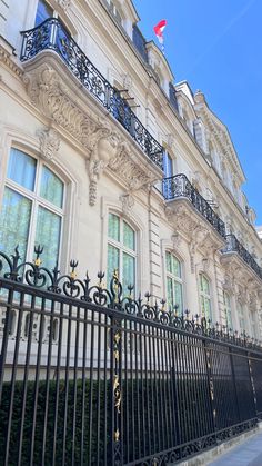 an iron fence in front of a white building