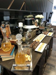 a table topped with lots of desserts and bottles filled with liquid on top of it