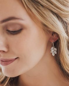 a close up of a woman wearing earrings with flowers on it's earring