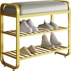 four pairs of shoes are on a gold shoe rack with white and gray sneakers hanging from it