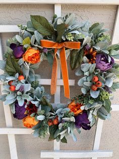 a wreath with orange, purple and green flowers