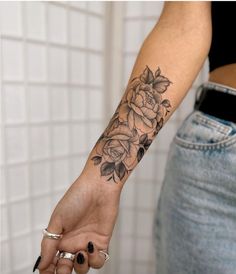 a woman's arm with a rose tattoo on it