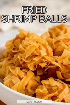 a bowl filled with fried shrimp balls on top of a wooden table and text overlay reads, fried shrimp balls