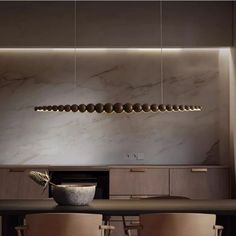 an elegant dining room with marble walls and wooden furniture, along with modern lighting fixtures