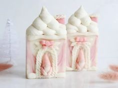 two pink and white candy houses sitting next to each other