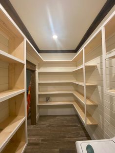 an empty walk in closet with shelves and dryer