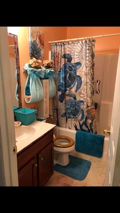 a bathroom with a toilet, sink and shower curtain in it's center area