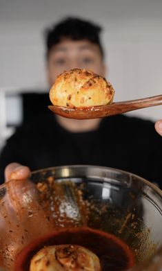 a person holding a spoon with some food in it