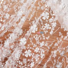 white flowers and sequins embellished on sheer mesh fabric, closeup