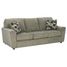 a gray couch with two pillows on it's back and one arm facing the camera