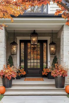 two large planters filled with pumpkins sit on the front steps of a house