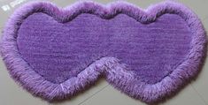 two purple hearts shaped rugs sitting on top of each other