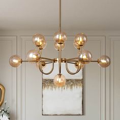 a chandelier hanging from a ceiling in a room with white walls and gold trim