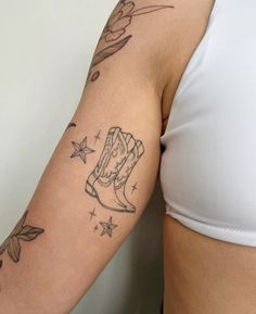 a woman's arm with tattoos on it, and a boot tattoo in the middle