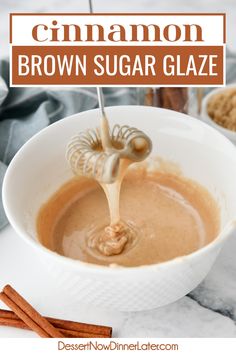 cinnamon brown sugar glaze is being poured into a white bowl with cinnamon sticks on the side