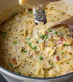 a ladle scooping some food out of a pot filled with macaroni and cheese