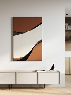 an abstract painting hangs on the wall above a white entertainment center with two black birds