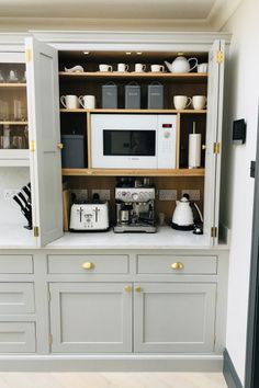 a kitchen with gray cabinets, white appliances and gold trim on the doors is seen in this image