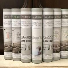 six cans of furniture paint sitting on top of a shelf in front of a wooden door