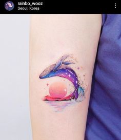 a colorful whale tattoo on the arm