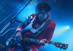 a man playing an electric guitar on stage