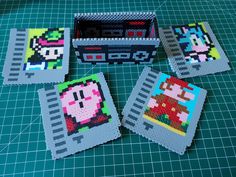 four pixel art coasters sitting on top of a green table next to each other