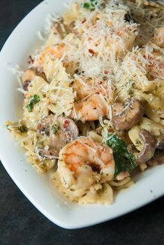 a white plate topped with pasta and shrimp