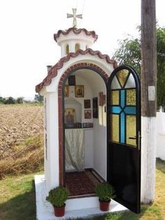 a small church with a stained glass window on the front door and an arched doorway